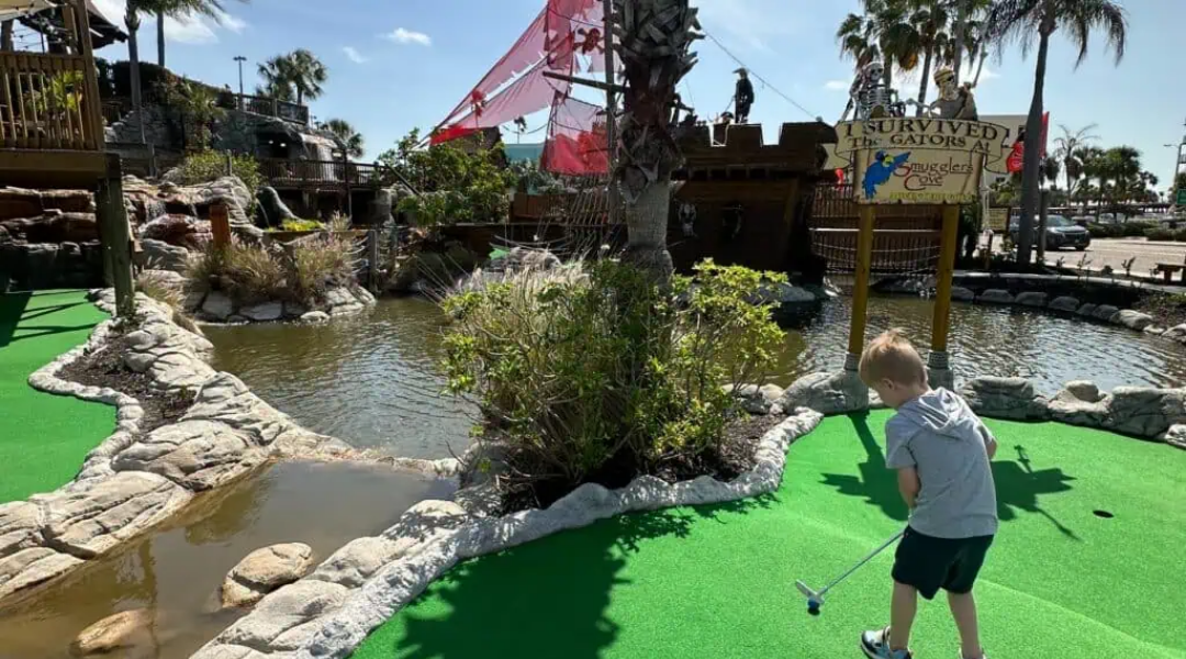 Child playing mini golf at Smugglers Cove Adventure Golf