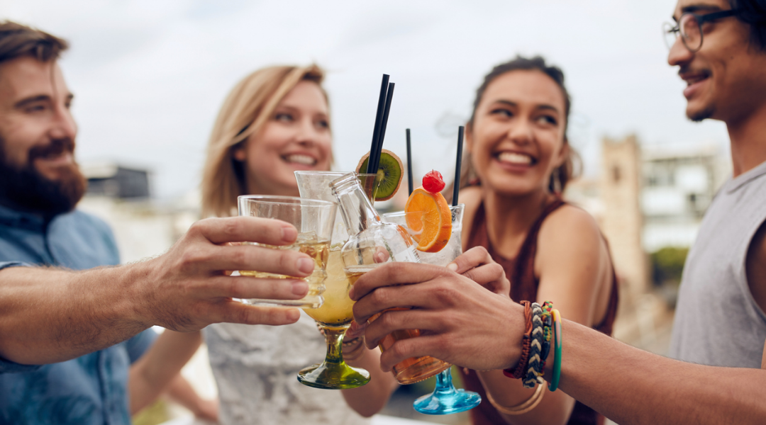 Friends toasting cocktails during a girls trip afternoon