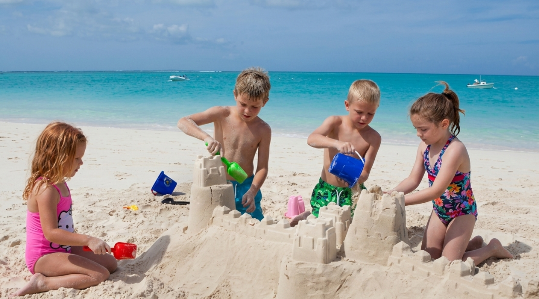 Kids building a large sandcastle on the beach